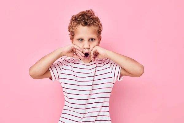 Porträtt av en pojke barndom leende spelar rosa färg bakgrund — Stockfoto