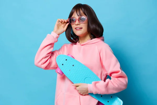 Vacker kvinna i en rosa tröja skateboard underhållning Livsstil mode — Stockfoto