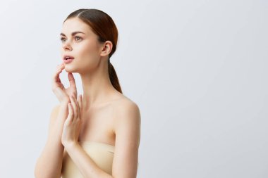 Kızıl saçlı, çıplak omuzlu bir portre. Kozmetik cilt bakımı.