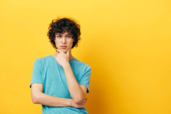 Cheerful teenager in a blue t-shirt on a yellow background — Stock Photo, Image