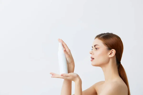 Ritratto donna cura della pelle lozione con spalle nude sfondo chiaro — Foto Stock