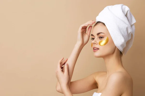 Bella donna con un asciugamano sulla testa gesticolando con le mani la cura della pelle sfondo isolato — Foto Stock
