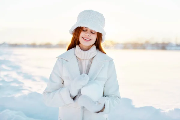 Güzel kadın gülümse kış havasında yürü beyaz palto doğanın ellerinde — Stok fotoğraf