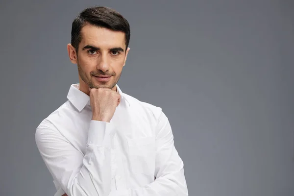 Hombre en una camisa blanca un aspecto pensativo fondo gris — Foto de Stock