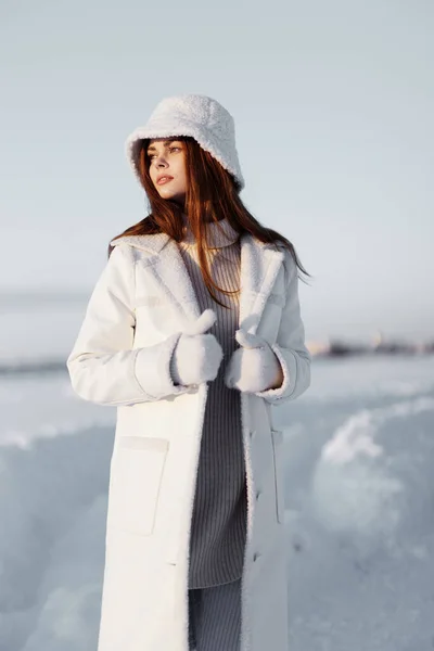 Młoda kobieta w białym płaszczu w kapeluszu zimowy spacer krajobraz Świeże powietrze — Zdjęcie stockowe