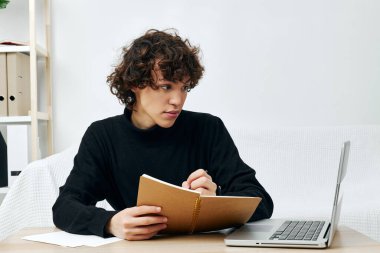 Masadaki koltukta oturan adam bir dizüstü bilgisayarın önünde yaşam tarzı teknolojisi.