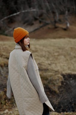 Sonbahar kıyafetleri içinde turist doğa ağaçları manzara gezer.