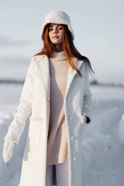 Piękna kobieta w białym płaszczu w kapeluszu zimowy spacer krajobrazowy — Zdjęcie stockowe