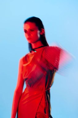 Güzel bir kadın kırmızı ışık gümüş zırh zincir posta mavi arka plan