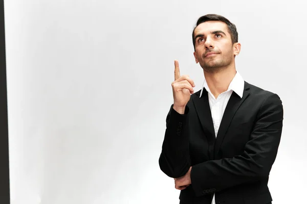 Man in a modern suit looking up showing index finger emotion self-confidence official — Stock Photo, Image