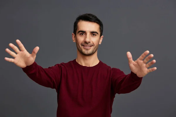 Guapo hombre posando sonrisa gesto manos rojo suéter recortado vista —  Fotos de Stock