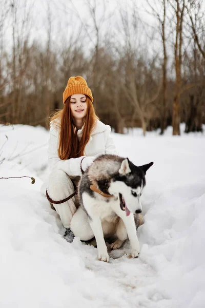 Mulher na neve brincando com um cão diversão amizade férias de inverno — Fotografia de Stock