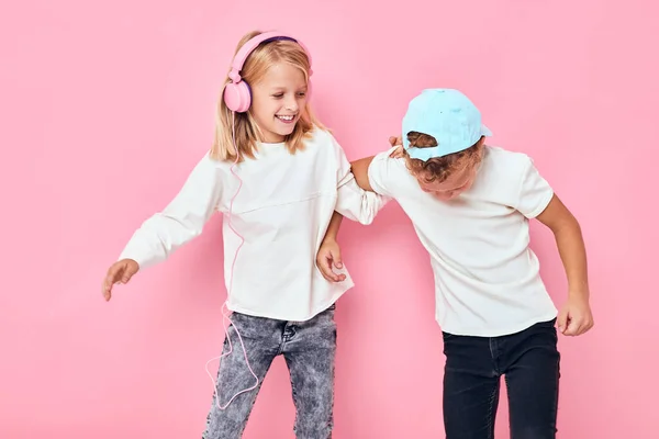 Un chico con gorra y una chica escuchando música estilo de vida infancia —  Fotos de Stock