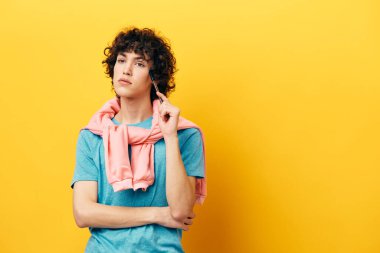 Yüz okulunun yanındaki kıvırcık erkek kalem sarı arka planı öğreniyor.