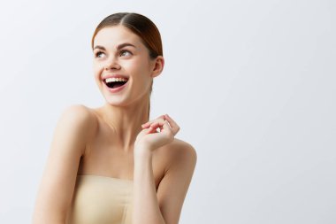 Kadın kızıl saçlı, çıplak omuzlu, kozmetik cilt bakımlı.