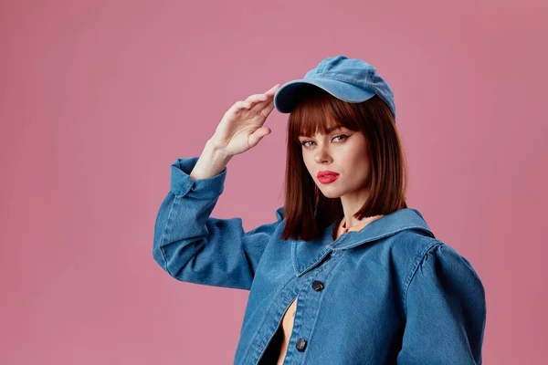 Beautiful fashionable girl in a cap and denim jacket posing studio model unaltered — Stockfoto