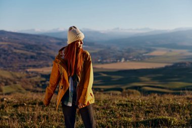 Kadın gezgin dağlara gezintiye çıktı güneşli bir gün