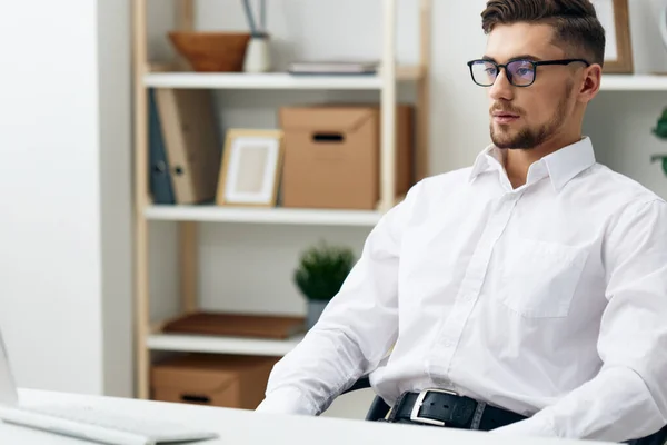 Gestionnaire portant des lunettes est assis à un bureau de bureau a travaillé bureau — Photo