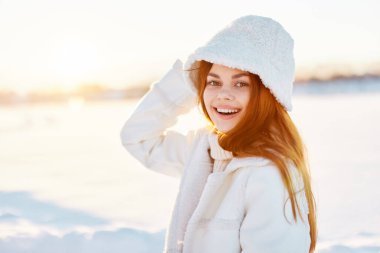 Beyaz önlüklü güzel bir kadın kış manzarası yürüyüşü yapıyor.