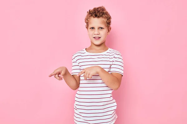 Porträtt av en pojke i en randig t-shirt rosa färg bakgrund — Stockfoto