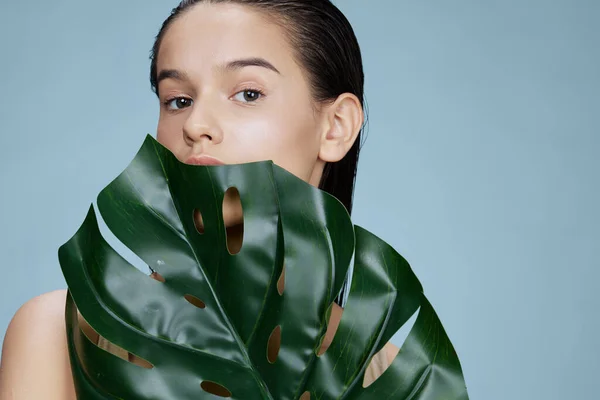 Hoja de palma verde mujer joven cerca de la cara de cerca Lifestyle —  Fotos de Stock