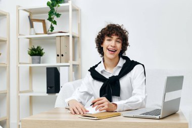 Genç dizüstü bilgisayar beyaz kanepede oturuyor online eğitim iletişimi