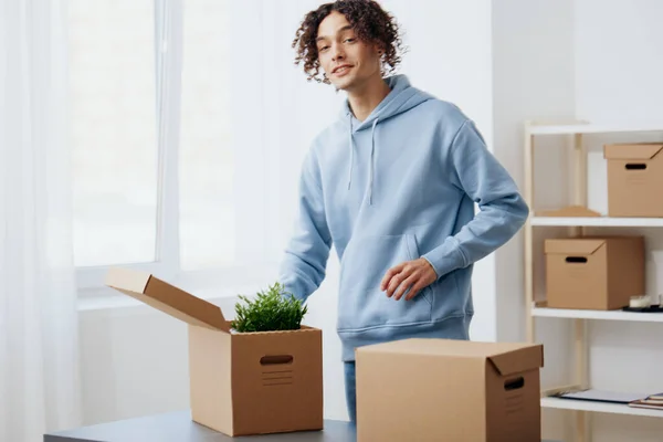 Porträt eines Mannes beim Auspacken von Sachen aus Kartons im Raum — Stockfoto