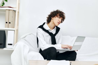 Adam dizüstü bilgisayarı beyaz koltukta oturuyor çevrimiçi yaşam tarzı eğitimi alıyor.