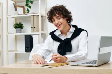 Kıvırcık adam internette dizüstü bilgisayar öğreniyor. Ev içi iletişim.