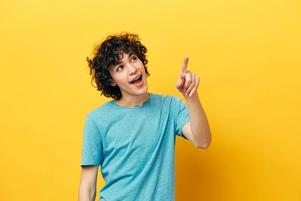 巻き毛の幸せな男は親指を上に黄色の背景 — ストック写真