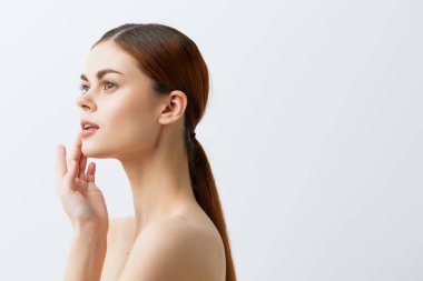 Portre kadını, kızıl saçlı, çıplak omuzlu, kozmetik ciltli, açık arkaplan.