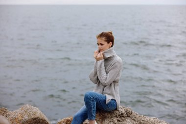 Güzel kadın plaj turizmi bulutlu hava taşlı kıyı yaşam tarzı