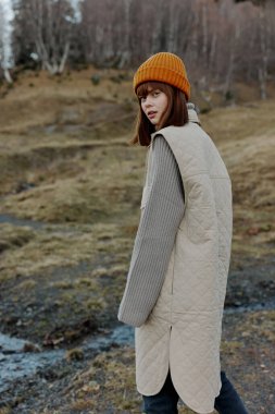 Turuncu şapkalı genç kadın. Sonbahar nehri yaşam tarzı.