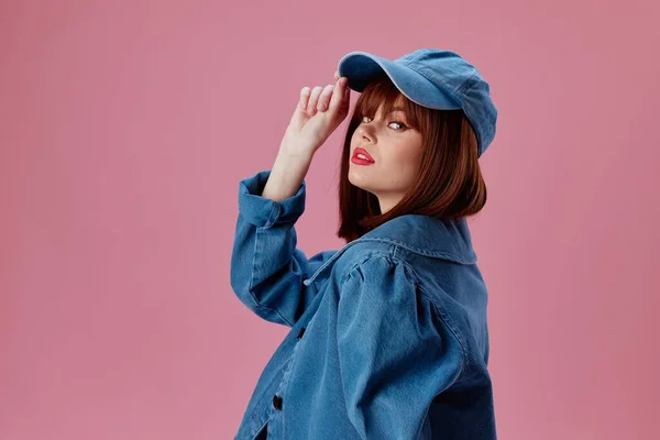 Красива модна дівчина в шапці і джинсовій куртці позує студійну модель незмінною — стокове фото
