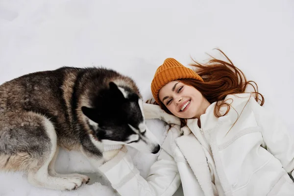 一个女人的画像 冬天穿的衣服在雪地里遛狗 高质量的照片 — 图库照片