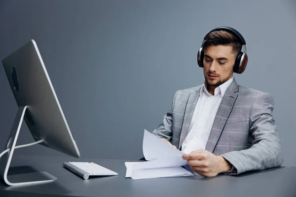Homem Bonito Sentado Com Fones Ouvido Documentos Sobre Computador Mesa — Fotografia de Stock