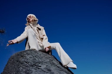 Sonbahar kıyafetleri içinde turist bir kaya manzarası üzerinde duruyor mavi gökyüzü rahatlaması. Yüksek kalite fotoğraf