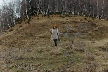 Sonbahar ormanında genç bir kadın temiz hava seyahati arazisinde yürüyor. Yüksek kalite fotoğraf