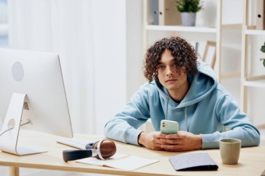 Bilgisayarın önünde masada oturan bir adamın portresi. Serbest yaşam tarzı.