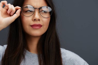 Tişört gözlüklü bir kadın portresi. Gençlik tarzı eğlenceli, soyutlanmış bir arka plan.