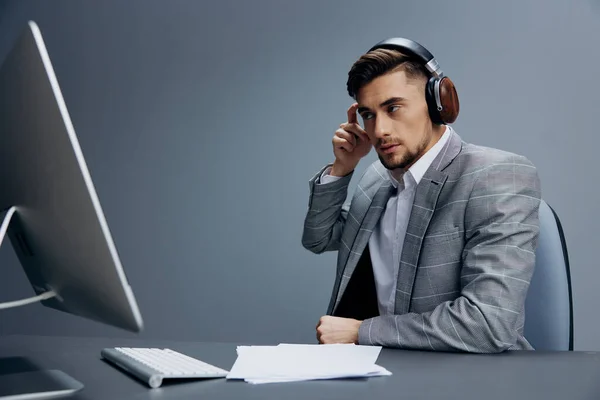 Empresários sentados com fones de ouvido documentos sobre o computador de mesa fundo isolado — Fotografia de Stock