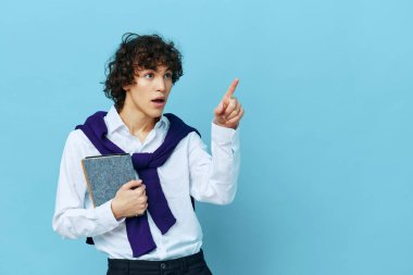 Omuzlarında süveter tişörtü olan, arka planda izole edilmiş not defteri olan adam.