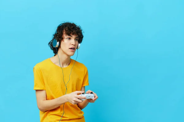 조이스틱 비디오 게임 격리 된 배경을 가진 곱슬곱슬 한 남자노란 티셔츠 — 스톡 사진