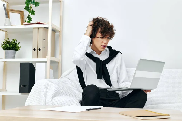 Man op een witte bank in de voorkant van een laptop leren Lifestyle technologie — Stockfoto