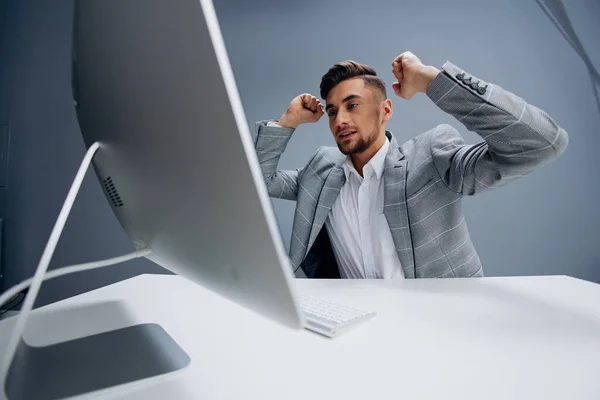 Bonito homem trabalhando no o computador no o escritório cinza fundo — Fotografia de Stock