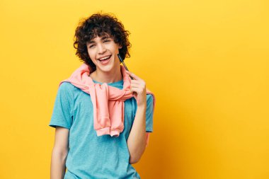 Yüz okulunun yanındaki kıvırcık erkek kalem sarı arka planı öğreniyor.