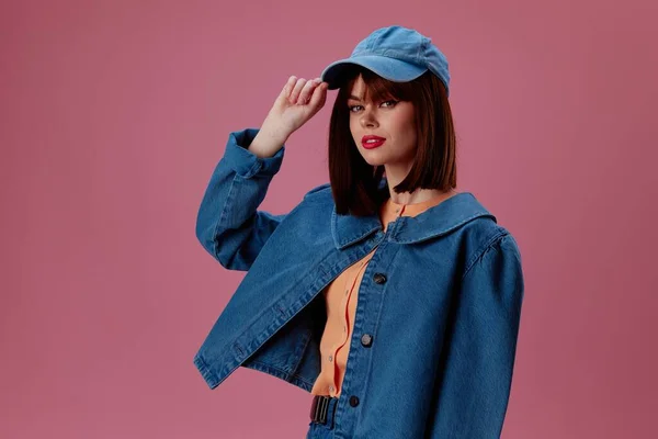 Söt ung kvinna i mössa och jeansjacka poserar studio modell oförändrad — Stockfoto