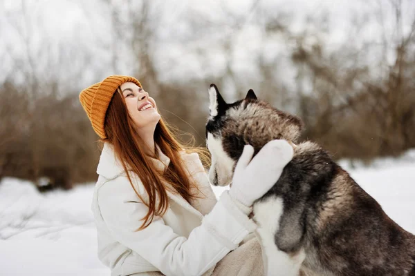 겨울옷을 입고 겨울 방학 때 개를 산책하는 여성 — 스톡 사진