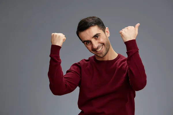 Portret man wijzend vingers naar de zijkant in een trui poseren hand gebaar emoties grijs achtergrond — Stockfoto