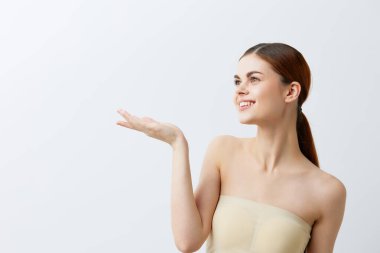 Güzel bir kadın, kızıl saçlı, çıplak omuzlu, kozmetik ciltli, izole bir arka plan.